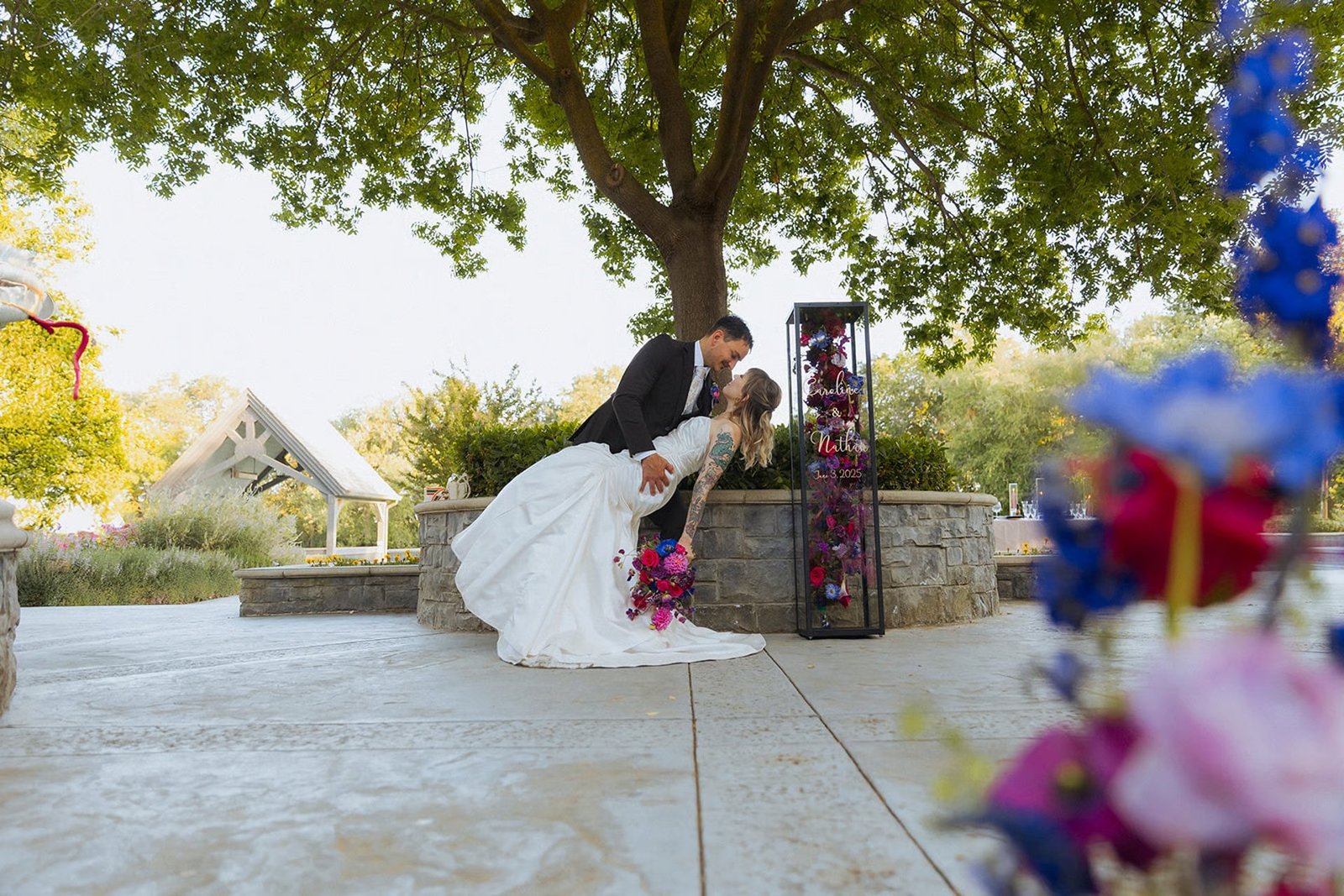 A couple on the stone terrace beside the floral tower